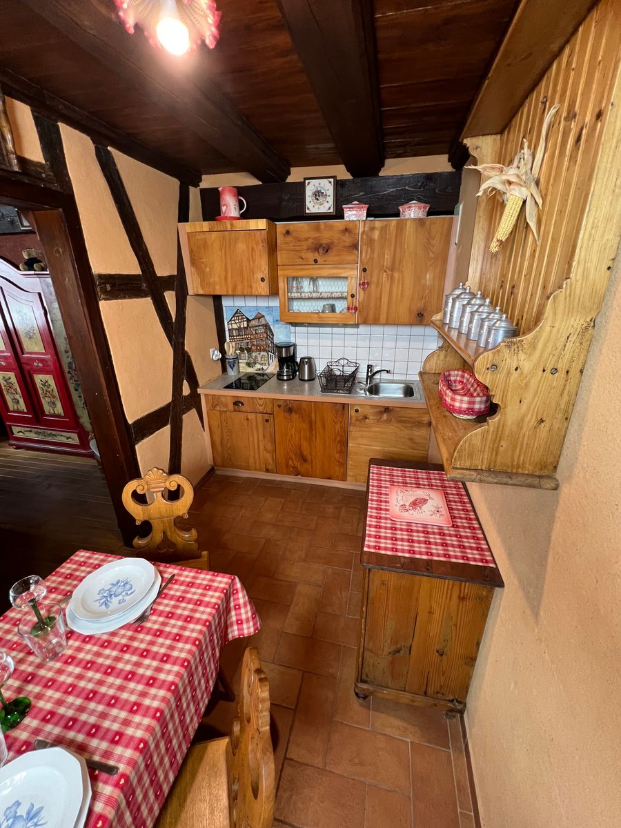 Coin repas avec ses deux chaises typiques ainsi qu'un banc, nappe et coussins faits avec du tissu imprimés de coeurs qui vous feront tomber amoureux à nouveau. Kitchenette équipée.