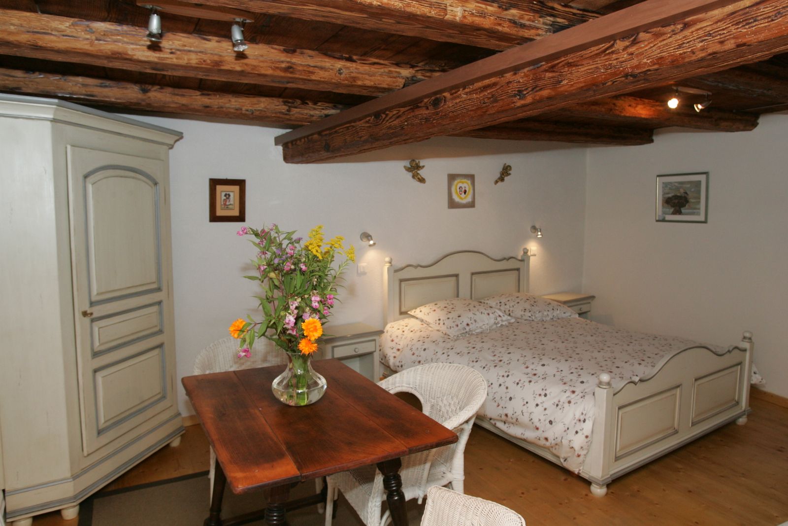 Chambre cosy, avec lit double confortable et ambiance chaleureuse. Poutres apparentes, mobilier rustique et détails soignés pour une nuit reposante en Alsace. Avec un espace repas, pour savourer les spécialités alsaciennes.